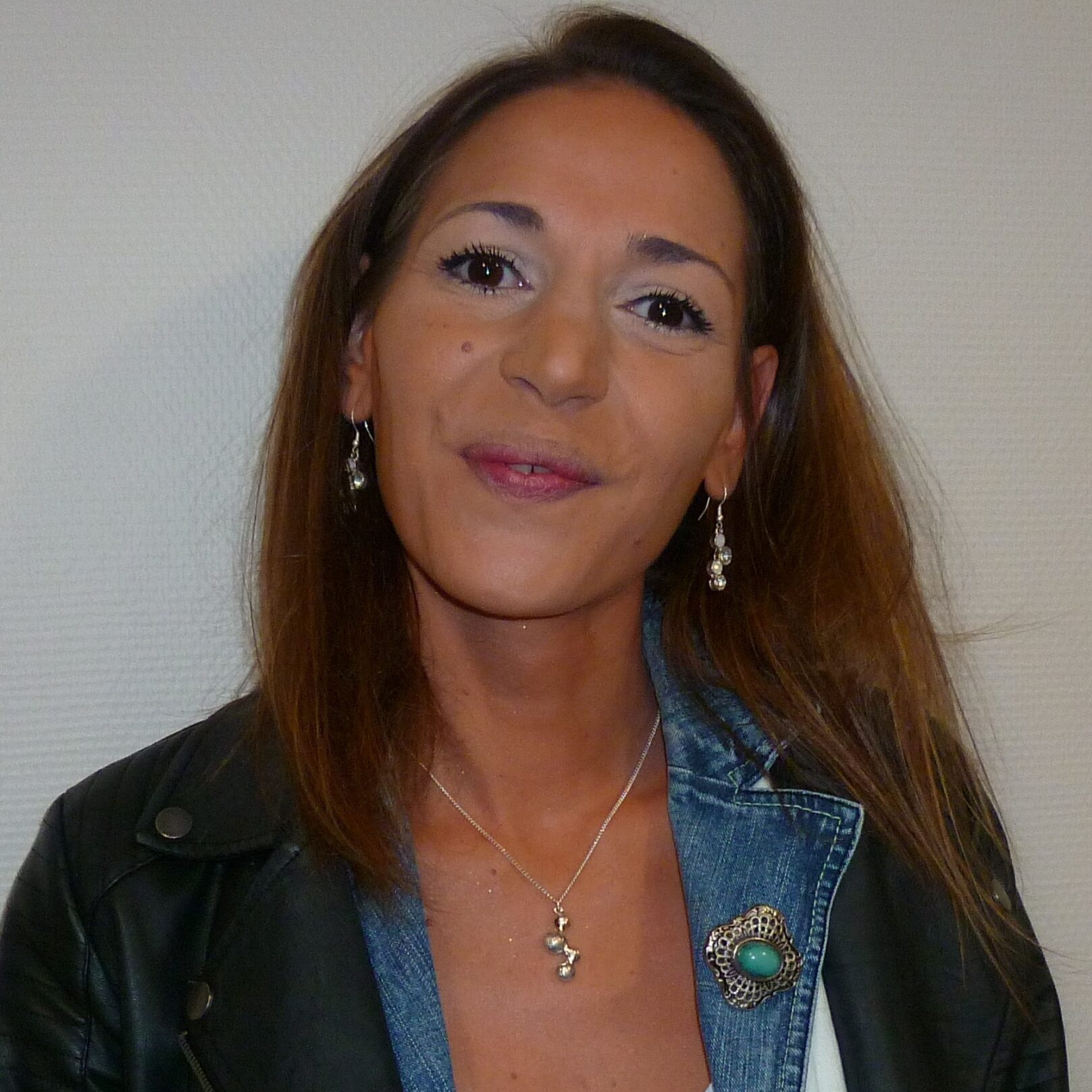 Portrait d’une femme souriante, veste en cuir et chemise rayée